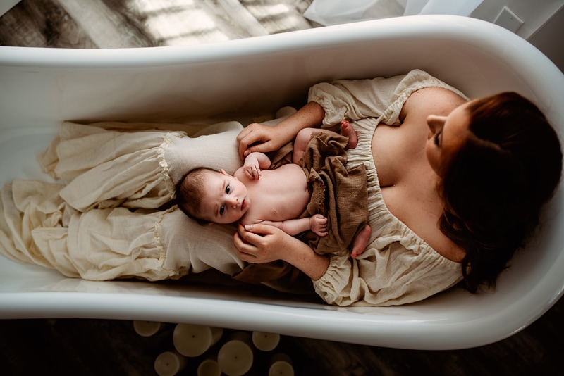 Maternity Photography, mother sitting in empty tub with baby resting on her legs
