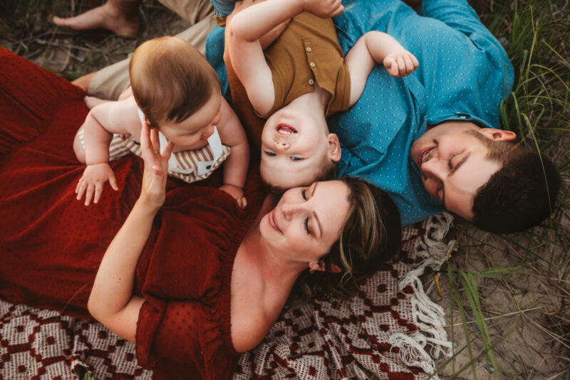 Family of Four lying on a blanket on the beach during a family photo session in Oshawa