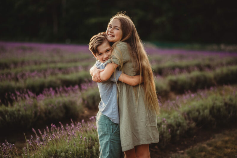 Brother and sister hugging in a field of lavender