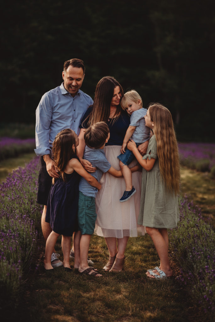 family of five hugging during a family photography session at
 a lavender field



