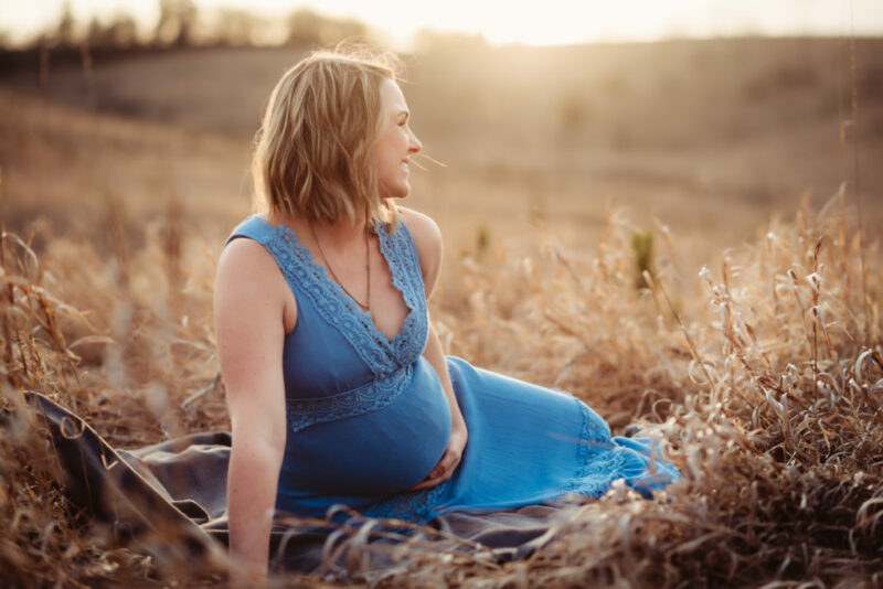Maternity session with a pregnant mother in a field a sunset