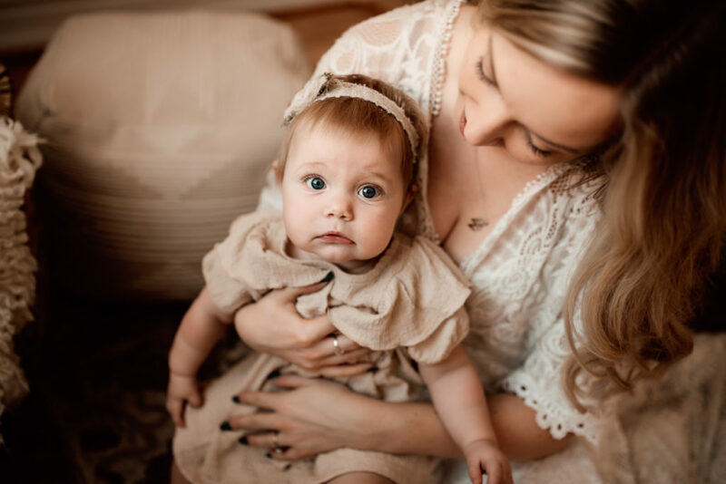 Young baby girl in her mother's arms during a whitby motherhood session