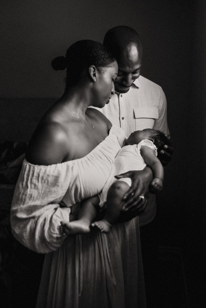 Black and white image of a mother and father holding their baby taken by a durham newborn photographer
