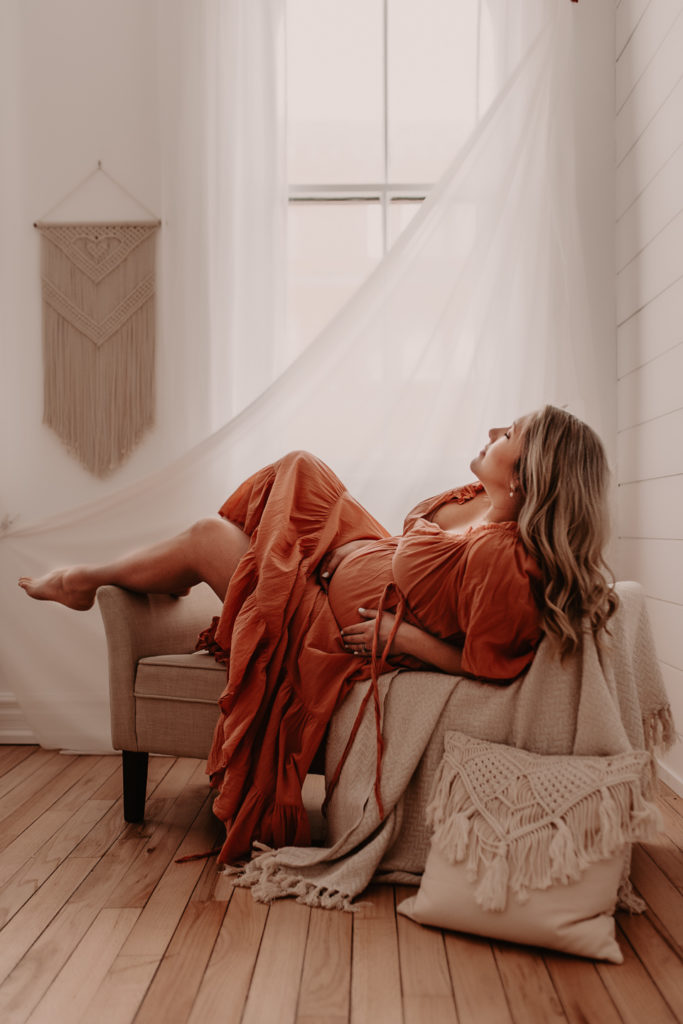 Pregnant woman lying on a stool during an in-studio Oshawa maternity photography session