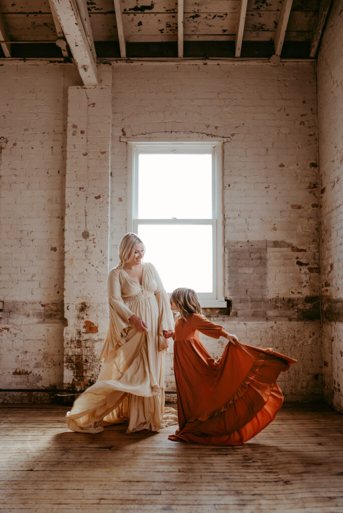 Mother and daughter spinning in long dresses in a warehouse studio in Hamilton