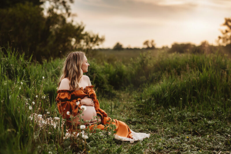 Pregnant woman holding her belly during a maternity photo session in Oshawa