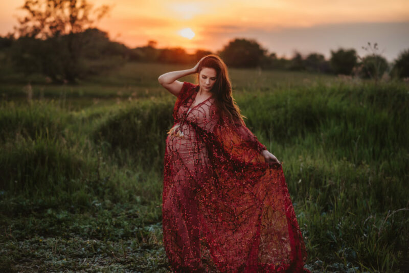 pregnant woman in a field at sunset