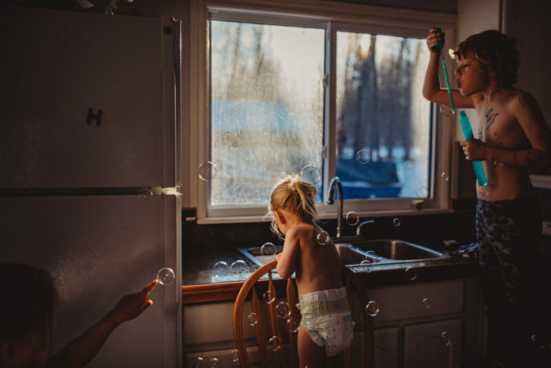 Photograph of kids playing at the kitchen sink