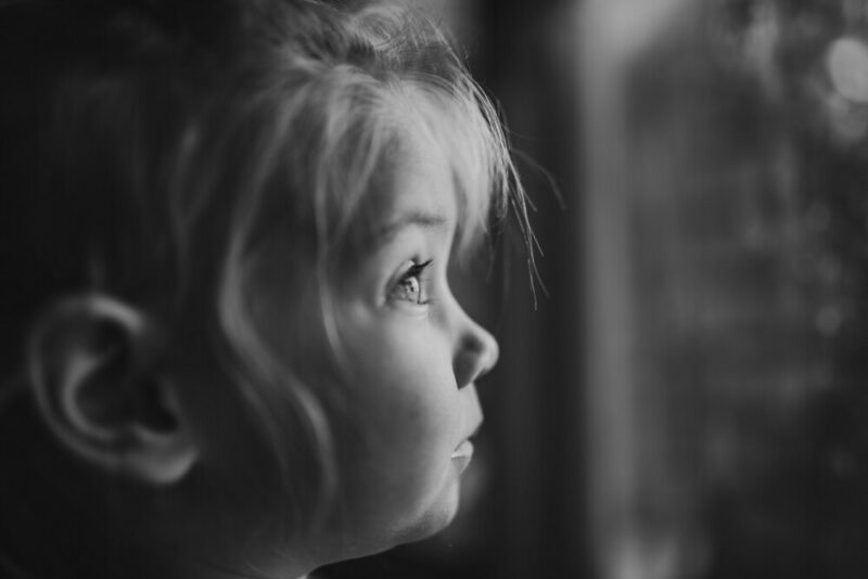 Close up of young girl looking out the window